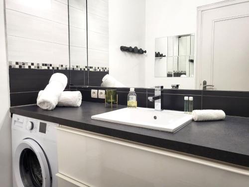 a bathroom with a sink and a washing machine at FAC 4 - Tram au pied l'immeuble- Parking free in Toulouse