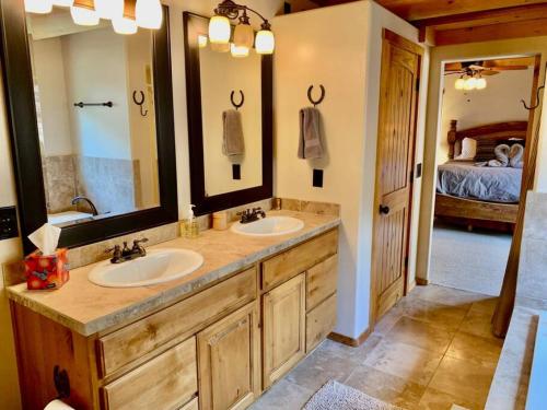 a bathroom with two sinks and a large mirror at Hilltop Chalet-Stunning Views, 3mi from downtown in Prescott