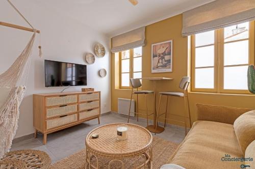 ein Wohnzimmer mit einem Sofa und einem TV in der Unterkunft Beethoven - St Michel - Métro - Tram - Stadium in Toulouse