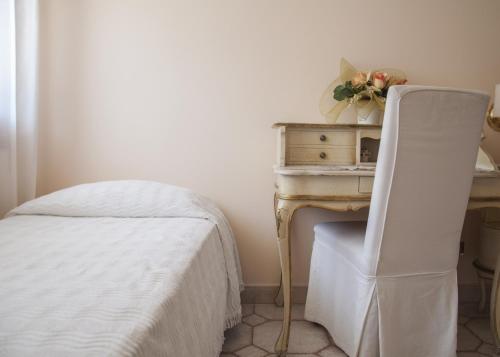 a bedroom with a bed and a desk with a chair at Hotel Villa Serena in Marghera