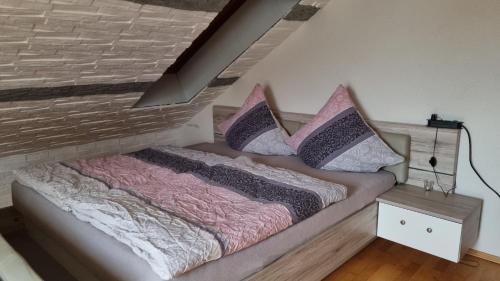 a bed with pillows on it in a room at Schöne 4-Zimmer-Ferienwohnung zu vermieten in Löffingen