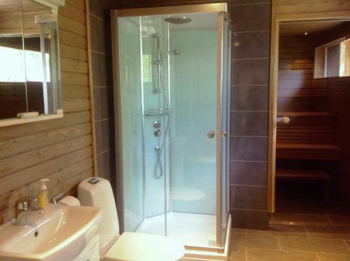 uma casa de banho com um chuveiro, um WC e um lavatório. em Inarin Kalakenttä em Inari
