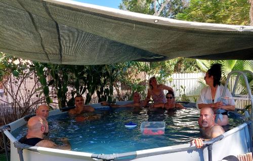 a group of people sitting in a swimming pool at The Lowest Place on Earth B&B in Neʼot HaKikar