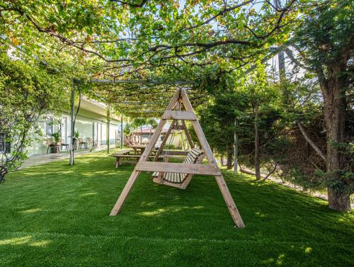 a wooden ladder sitting in the grass in a yard at Levada Apartment - Hellenic Apartments Avlona in Avlón