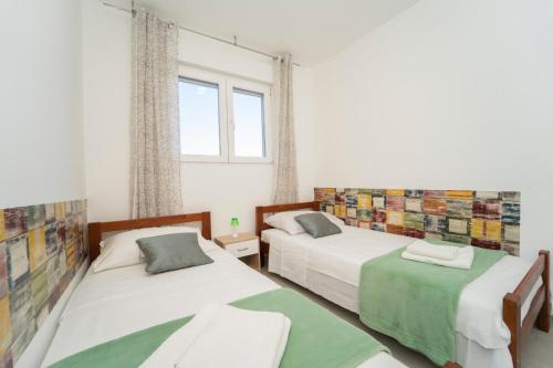 - une chambre avec 2 lits et une fenêtre dans l'établissement SVEMA APARTMAN, à Vela Luka