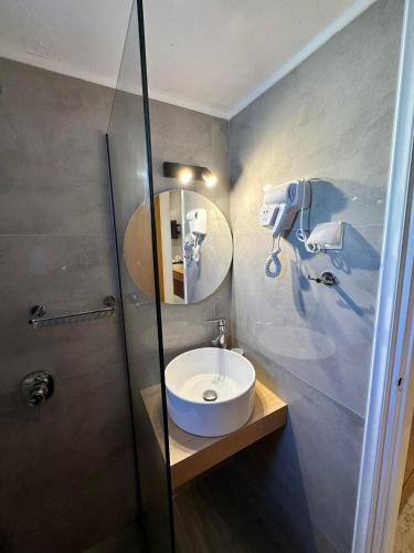 a bathroom with a sink and a mirror at Castro Hotel in Amoudara Herakliou