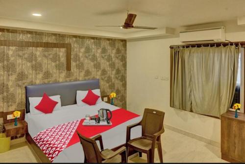 1 dormitorio con 1 cama con mesa roja y sillas en The Royal Comforts, en Visakhapatnam