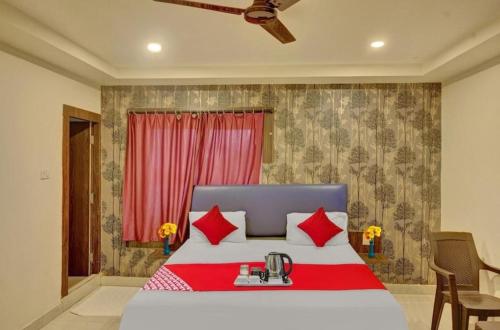 um quarto com uma cama grande e almofadas vermelhas em The Royal Comforts em Visakhapatnam