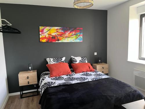 a bedroom with a black bed with two red pillows at La casa Tata in Taulé