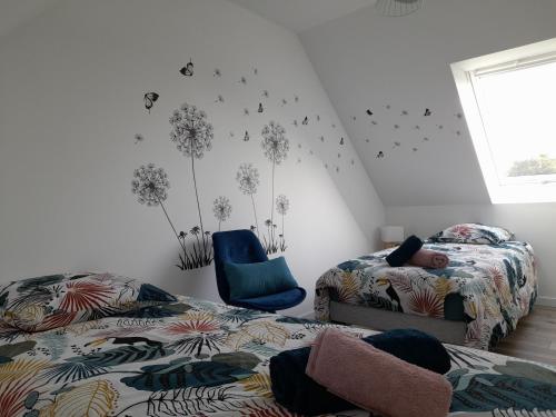 a bedroom with two beds and a blue chair at La casa Tata in Taulé