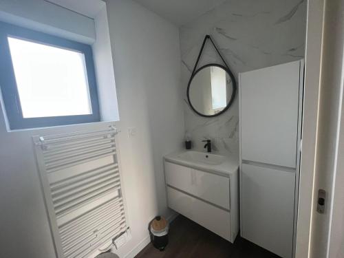 a white bathroom with a sink and a mirror at La casa Tata in Taulé