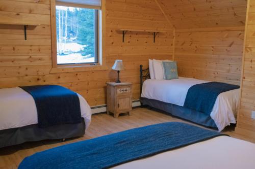 a room with two beds in a log cabin at Beyul Retreat in Meredith