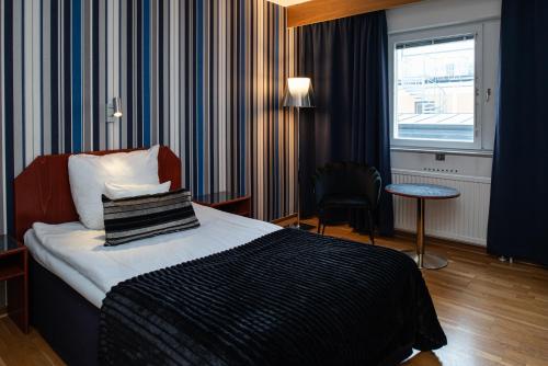 フディクスバルにあるQuality Hotel Stattのベッド、テーブル、窓が備わる客室です。