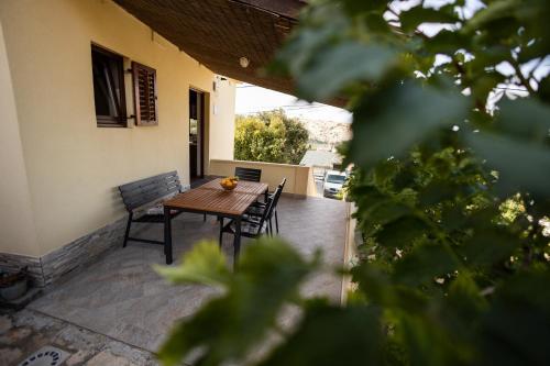 a wooden table and chairs on a patio at Apartman Marija in Lopar