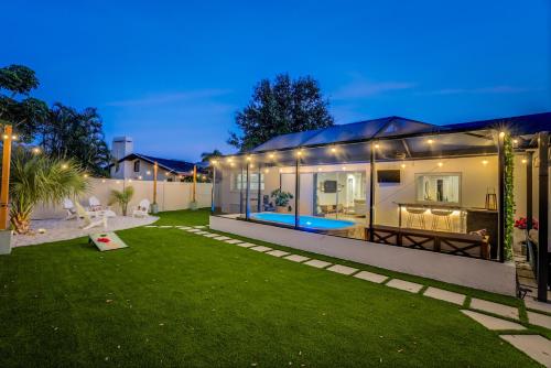 a home with a pool in the backyard at night at Cozy Clearwater Getaway Beach, Spa, and Luxury in Clearwater