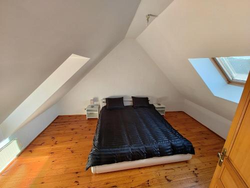 a bedroom with a black bed in the attic at Cosy Triplex 3 chambres in Pont-de-lʼArche