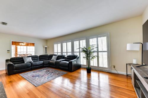 a large living room with a black leather couch at Jacksonville Vacation Home with Trout River Access in Jacksonville