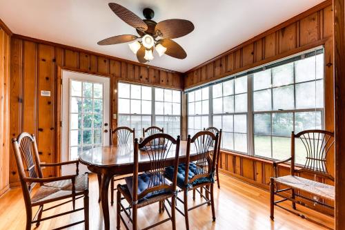 a dining room with a table and chairs and windows at Jacksonville Vacation Home with Trout River Access in Jacksonville