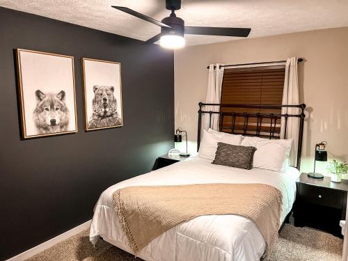 a bedroom with a bed with two pictures on the wall at Remodeled Summit Condo at Snowshoe - Modern & Cozy in Snowshoe