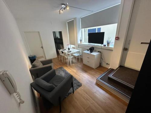 a living room with a couch and chairs and a television at Charming studio in bond street in London