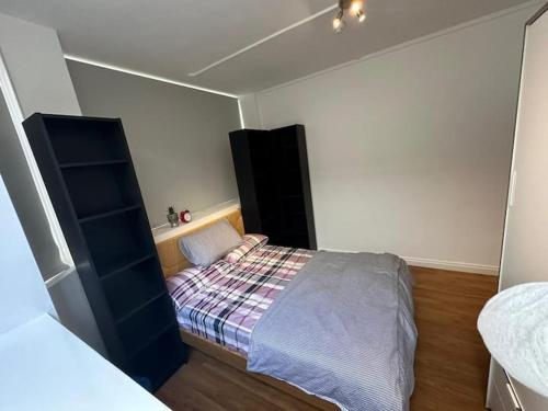 a small bedroom with a bed and a black cabinet at Charming studio in bond street in London