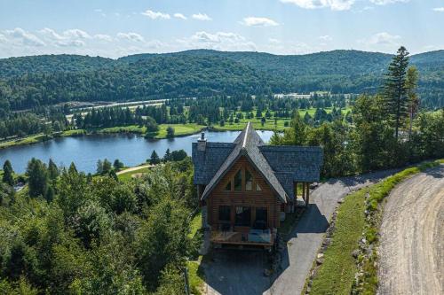 an aerial view of a house on a hill next to a lake at Eagle's Nest in Saint-Faustin