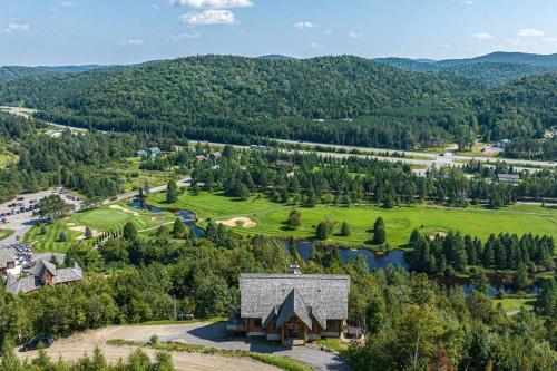 an aerial view of a resort with a building and a lake at Eagle's Nest in Saint-Faustin