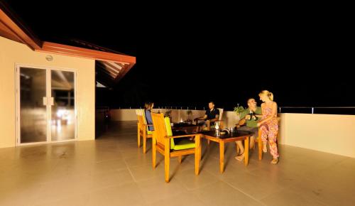 a group of people sitting around a dining room table at Antares Dhangethi & Spa in Dhangethi