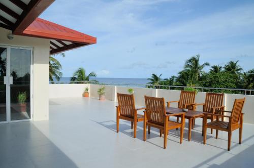a table and chairs on a balcony with the ocean at Antares Dhangethi & Spa in Dhangethi