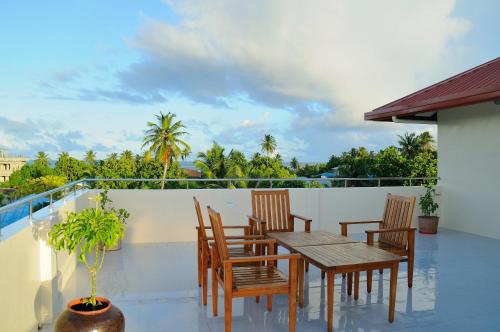 a patio with a table and chairs on a balcony at Antares Dhangethi & Spa in Dhangethi
