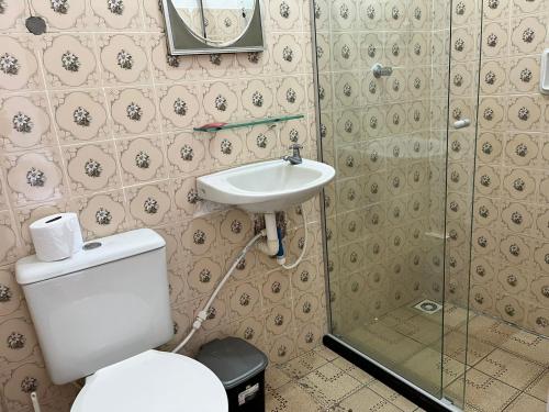 a bathroom with a toilet and a sink at Tia Preta Pousada in Morro de São Paulo