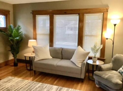 a living room with a couch and two windows at Whole House Cohassett in Lakewood