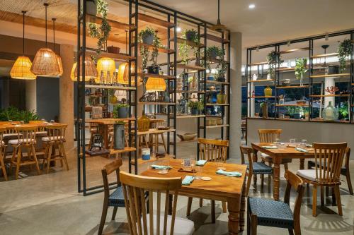 a restaurant with wooden tables and chairs and shelves at El Mangroove Papagayo, Autograph Collection in Papagayo, Guanacaste