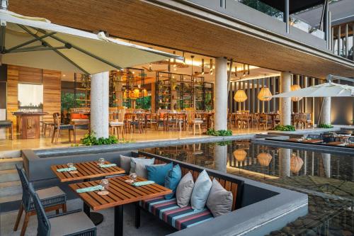 a restaurant with a pool and tables and chairs at El Mangroove Papagayo, Autograph Collection in Papagayo, Guanacaste