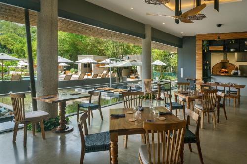 a restaurant with tables and chairs and a pool at El Mangroove Papagayo, Autograph Collection in Papagayo, Guanacaste
