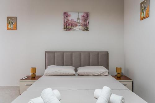 um quarto com uma cama e 2 toalhas brancas em Brand New Apartment- Great location Seafront with pool access em Durrës
