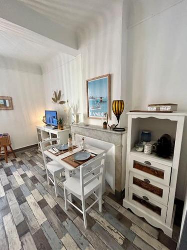 un salon avec des chaises blanches et une table dans l'établissement T2 hyper centre, à Bandol