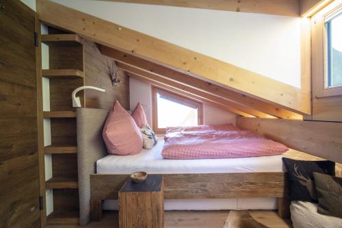 a bedroom with a bunk bed and a ladder at Bergchalet Flöna in Scuol