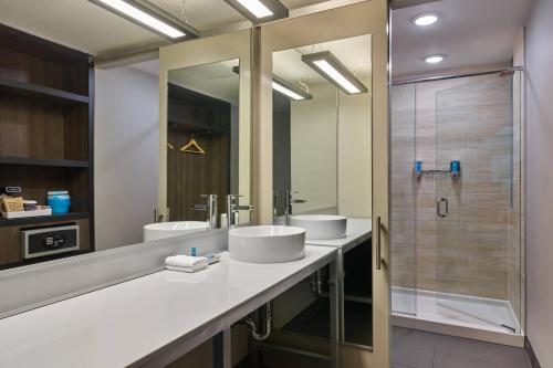 łazienka z 2 umywalkami i prysznicem w obiekcie Aloft Richardson w mieście Richardson