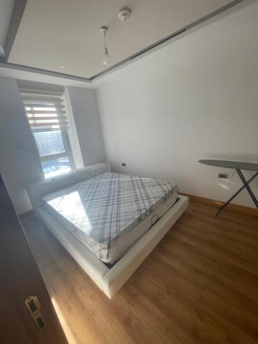 a bedroom with a bed in a room with a desk at FİNANSKENT SARPHAN RESİDANCE ATASEHİR in Istanbul