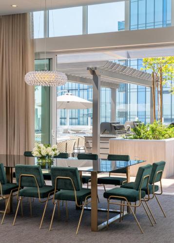 a dining room with a table and green chairs at Level Los Angeles - Downtown Flower in Los Angeles