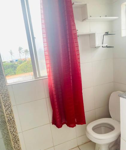 a red shower curtain in a bathroom with a toilet at Mini Casa Vista Mar in Salvador