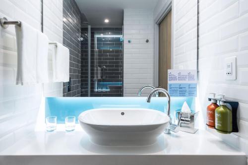 a white bathroom with a sink and a shower at Holiday Inn Express - Astana - Turan by IHG in Astana