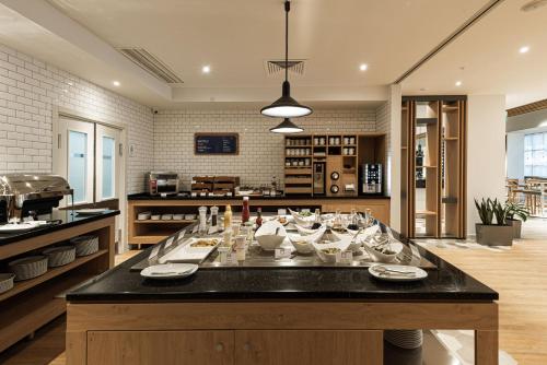 a large kitchen with a table with dishes on it at Holiday Inn Express - Astana - Turan by IHG in Astana