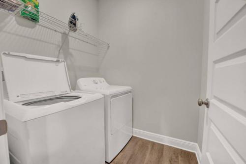 a white washer and dryer in a white laundry room at Joe's Beach House in Highland View