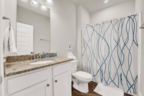 a bathroom with a sink and a toilet and a mirror at Joe's Beach House in Highland View