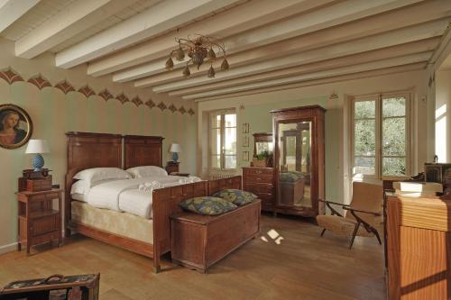 ein Schlafzimmer mit einem großen Bett und ein Zimmer mit einem Schreibtisch in der Unterkunft Villa Frida in Salò