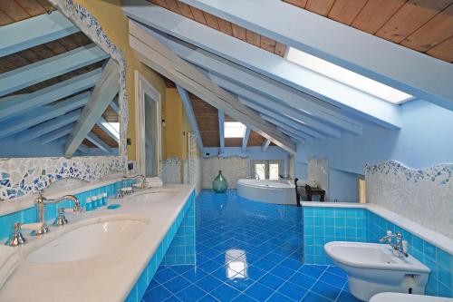 ein blaues Badezimmer mit zwei Waschbecken und einer Badewanne in der Unterkunft Villa Frida in Salò