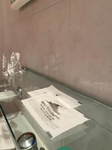 un sacchetto di carta poggiato su un tavolo di vetro di Hotel Mazzini a Lido di Jesolo