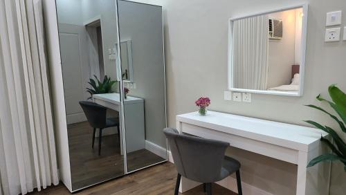 a bathroom with a mirror and a sink and chairs at شقة أنيقة لاقامة مثالية جيزان - وصول ذاتي in Jazan